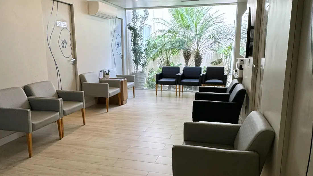 Sala de espera da unidade Tambauzinho, com poltronas e um jardim ao fundo